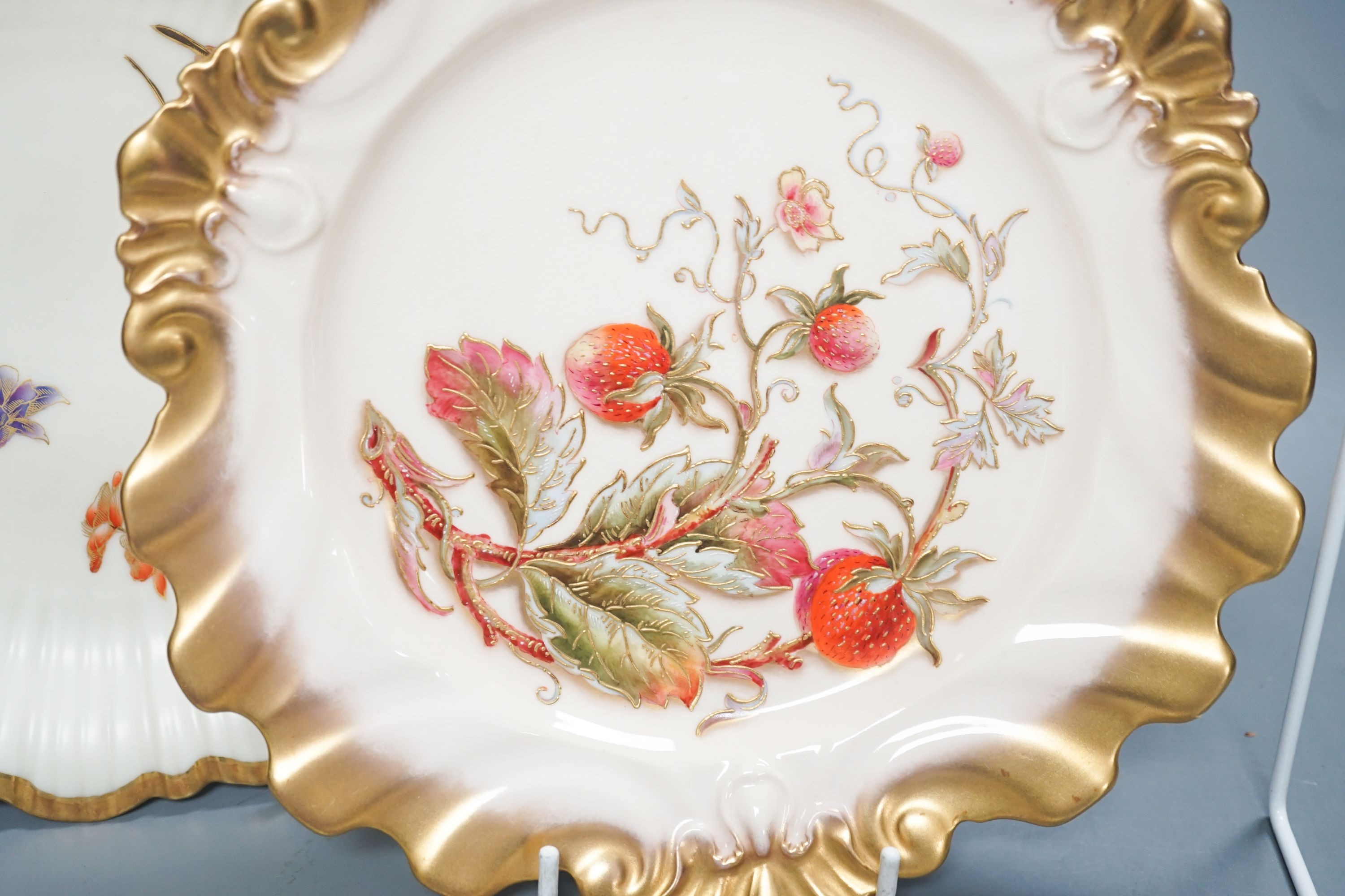 A Royal Worcester fine moulded plate painted and gilded with Strawberries by William Hale, signed WH verso, date mark 1890 and a pair of ivory moulded plates painted and gilded with tree branches, largest diameter 23cm